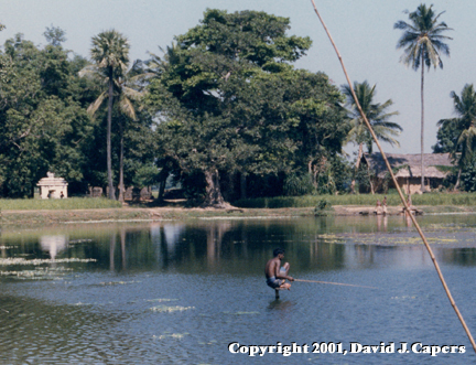 Surrounded by water on all sides, a lone fisherman awaits a nibble.