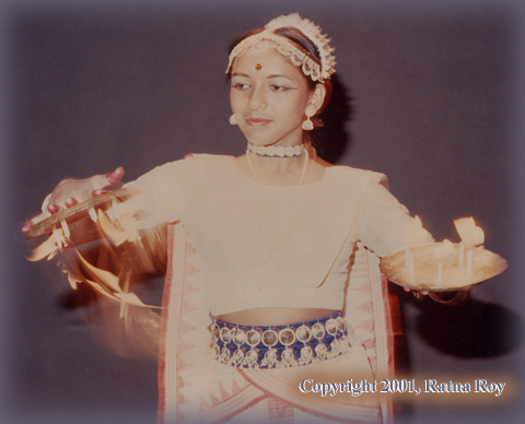 Shyamali Roy Hauth quickly flips the brass plates, with lit candles, upside down and rights them again to the beats of Orissi music.